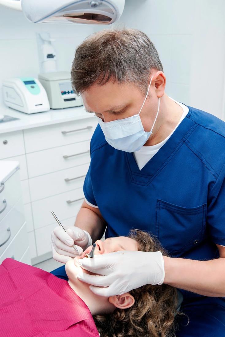Dentysta podczas przeglądu stomatologicznego pacjenta w gabinecie w Gdyni